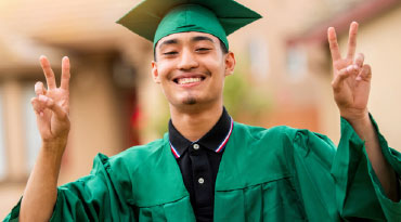 happy graduate giving double peace sign